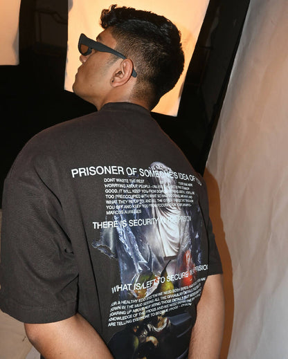 Male Model Showcasing Back of Prisoner of Mind T-Shirt viewed from back and wearing sunglasses in an evocative image