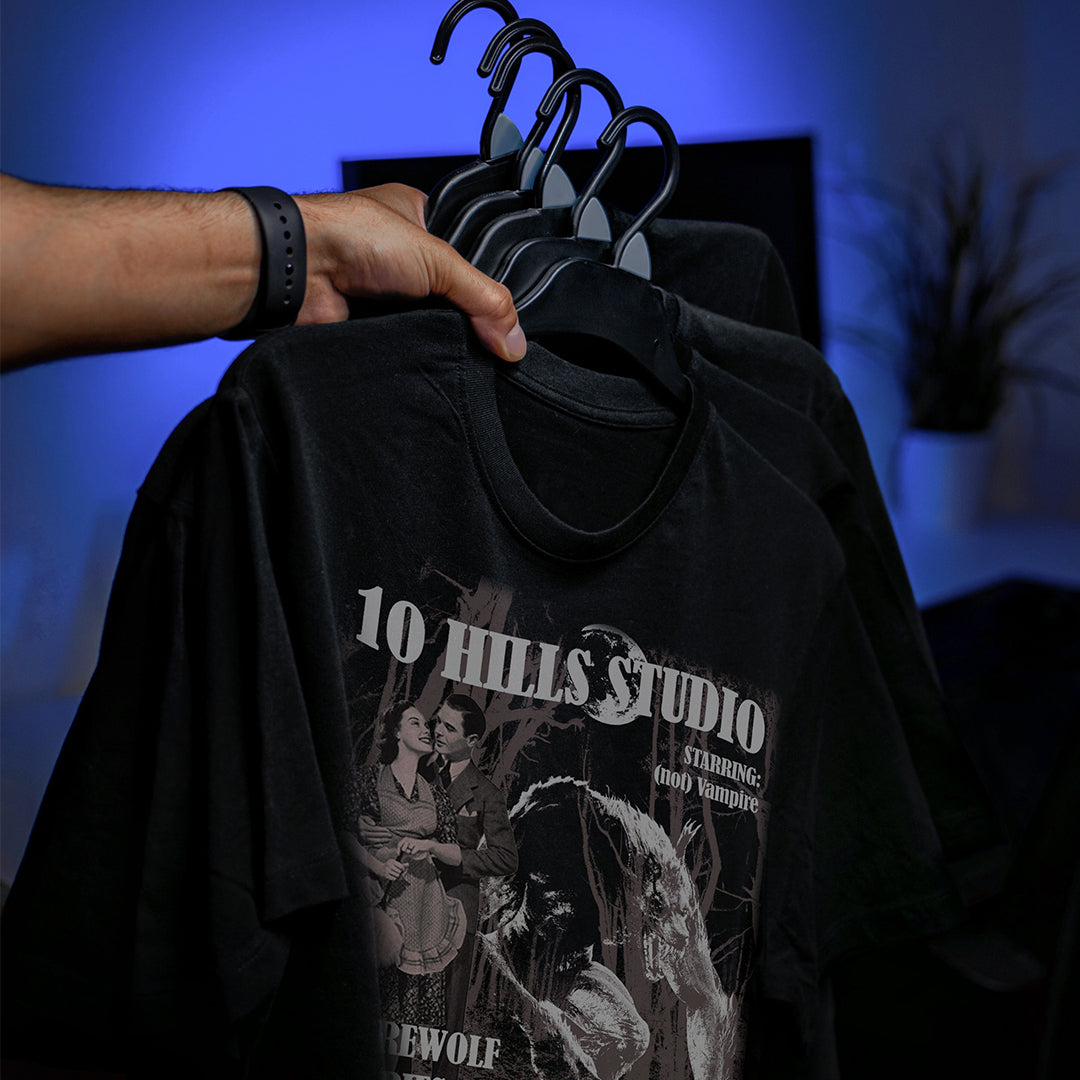 Close up of 10 Hills Studio Unisex 'Stop War' Black Boxy T-shirt on a hanger with blue mood lighting